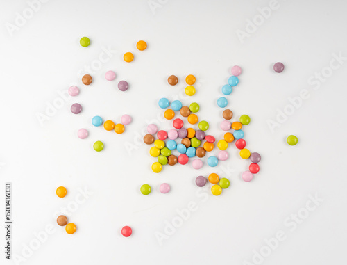 Scattered small candies isolated. Colorful dragees, multicolored glazed chocolate buttons