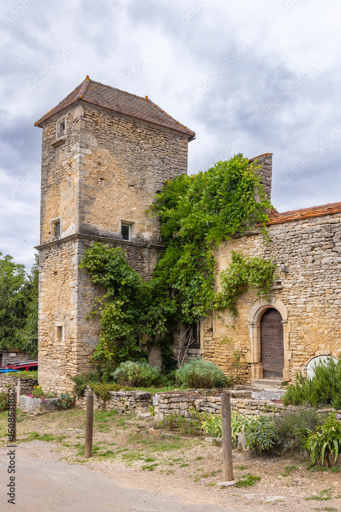 Fototapeta premium Ancient stone house with tower and climbing plants in Chateauneuf, Bourgogne Franche Comte, France