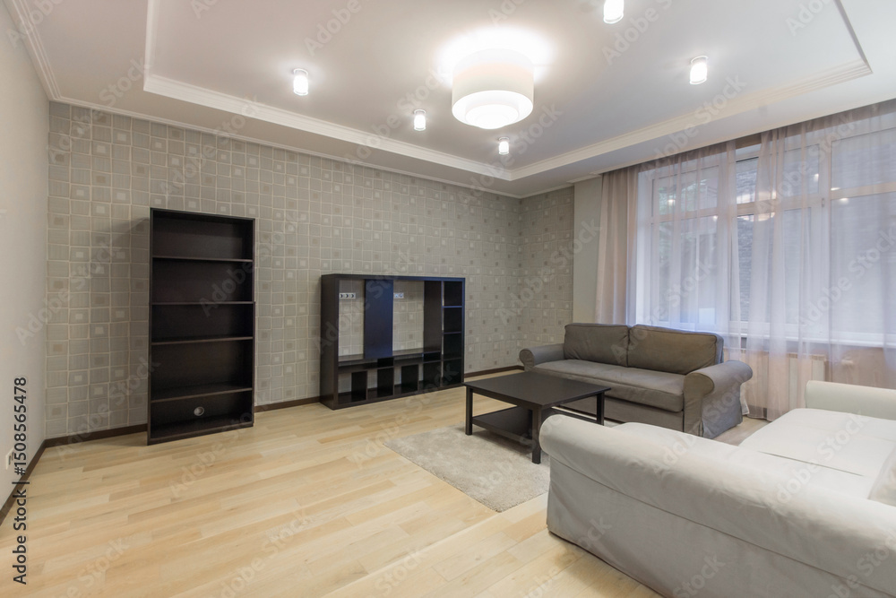 Fototapeta premium Spacious living room with a beautiful interior design. Fluffy carpet on the floor, elegant sofas. Window with tulle curtains.