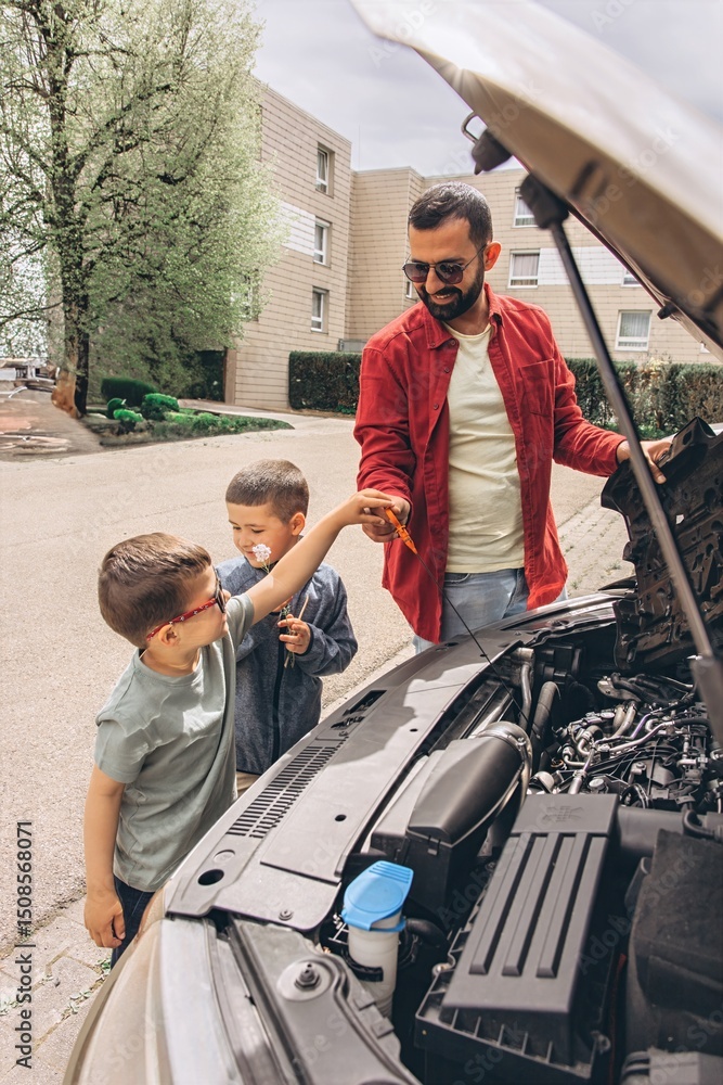 Naklejka premium Father and sons repairing car together with the hood open. A heartfelt moment of bonding, fatherhood, parenting, teamwork, and learning. Celebrating Father Day through shared hands-on experience.