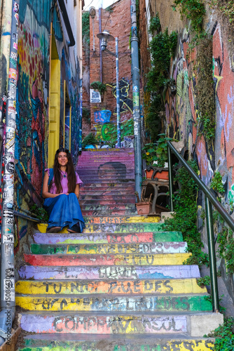 Young Woman Sitting on Colorful Staircase Tribute to Violeta Parra in Valparaíso, Chile – Urban Art, Cultural Landmark, Vibrant Street Scene