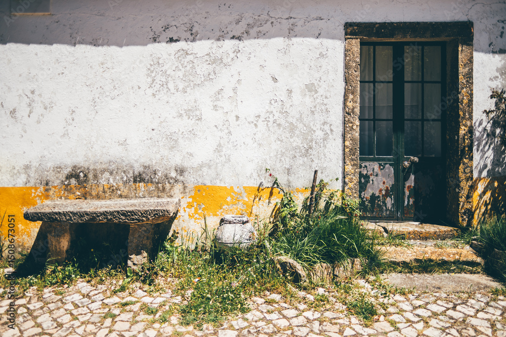 custom made wallpaper toronto digitalWeathered rustic wall with peeling white and yellow paint, old stone bench, ceramic jar, and overgrown grass next to a vintage door, ample copy space area on the left side