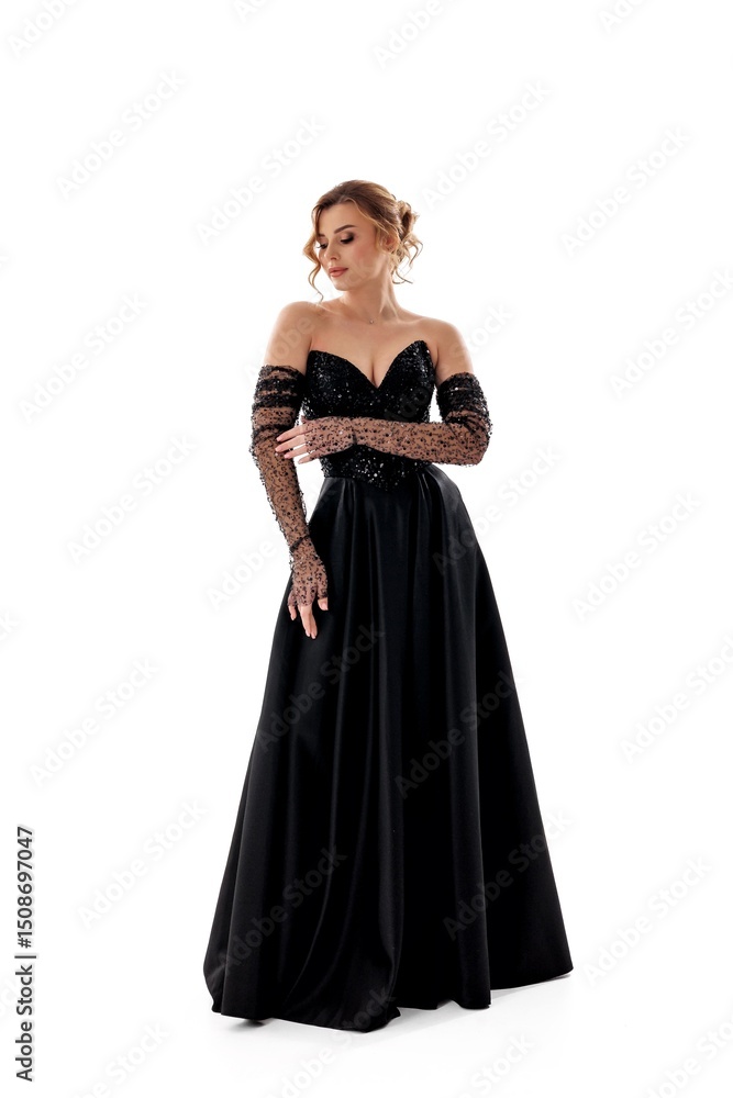 Elegant woman in black evening gown with embellished long sleeves poses gracefully against a white background Elegant woman in black evening gown with embellished long sleeves poses gracefully against a white background