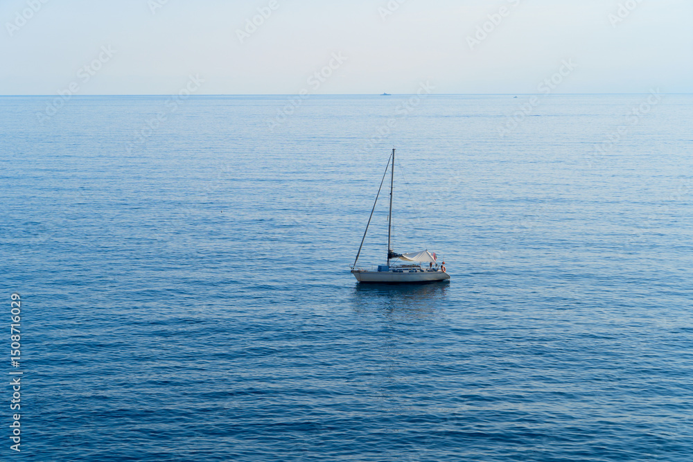 A serene, tranquil sailboat slowly gliding gracefully over the calm, beautiful ocean waters on a bright clear day A serene, tranquil sailboat slowly gliding gracefully over the calm, beautiful ocean waters on a bright clear day