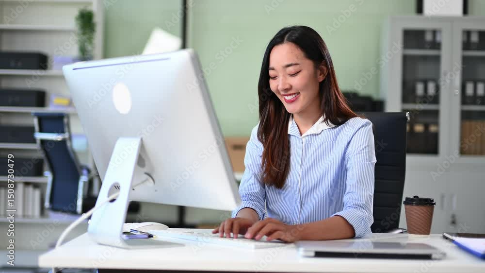 Confident Asian woman working at office desk with laptop and financial documents. Confident Asian woman working at office desk with laptop and financial documents.