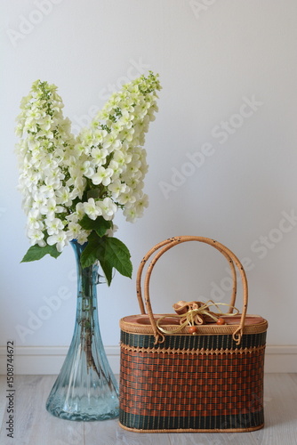花瓶に飾った柏葉アジサイと籠バックのテーブルフォト