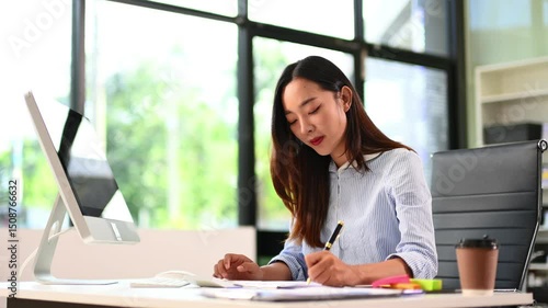 Asian business woman typing laptop and tablet Placed at the table at the office