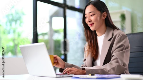 Asian business woman typing laptop and tablet Placed at the table and modern workplace lifestyle themes.