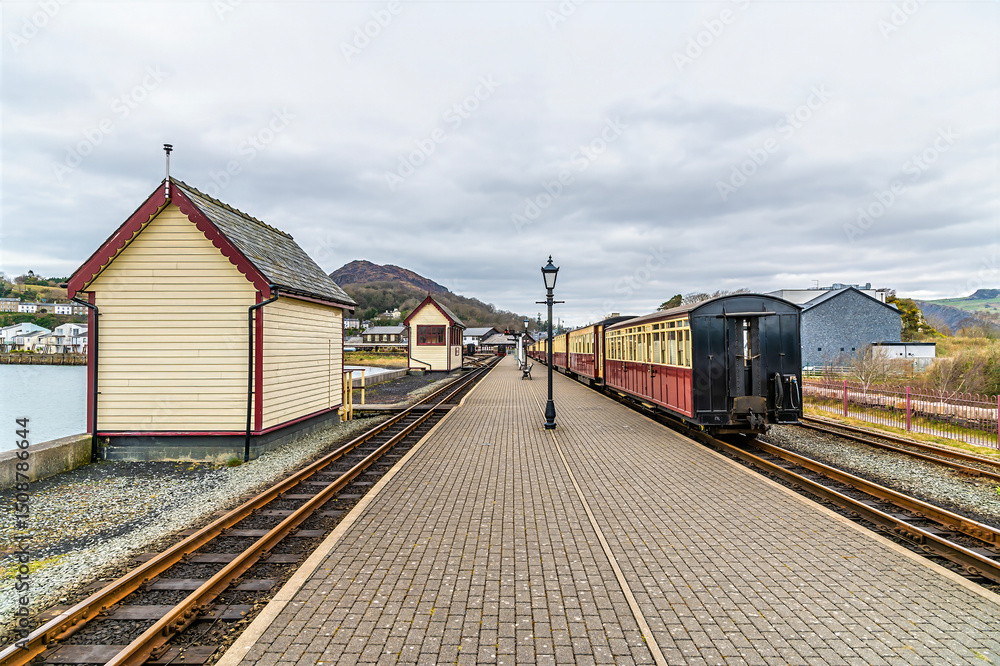 Obraz premium A view from the end of the platform towards the railway station at Porthmadog, Wales in springtime 