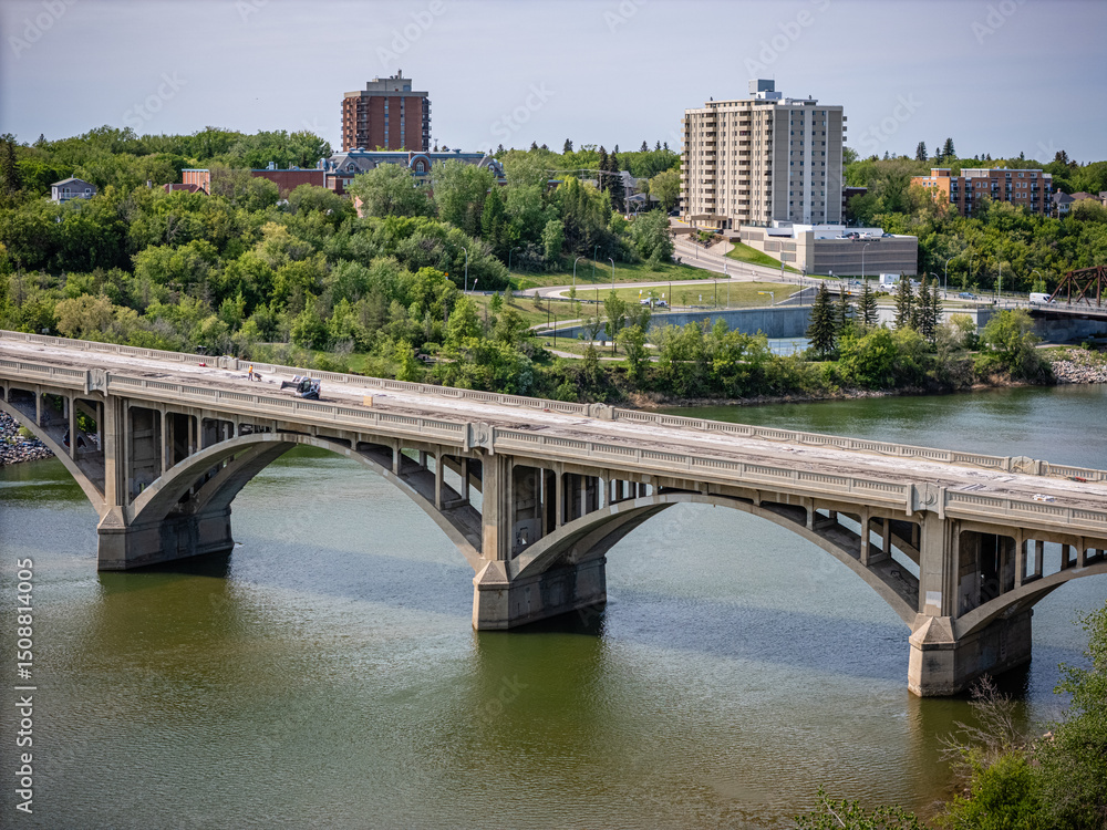 Fototapeta premium Bridge spans a river with a city in the background