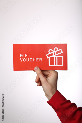 Top view of woman holding gift voucher lettering on white background
