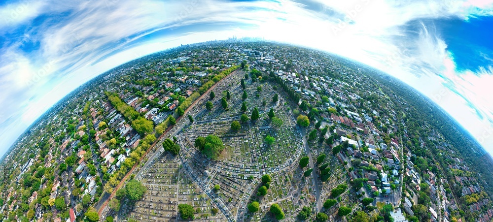 Obraz premium Aerial view of the Boroondara General Cemetery in Kew, with the Melbourne city skyline in the background, Victoria, Australia. March 2025