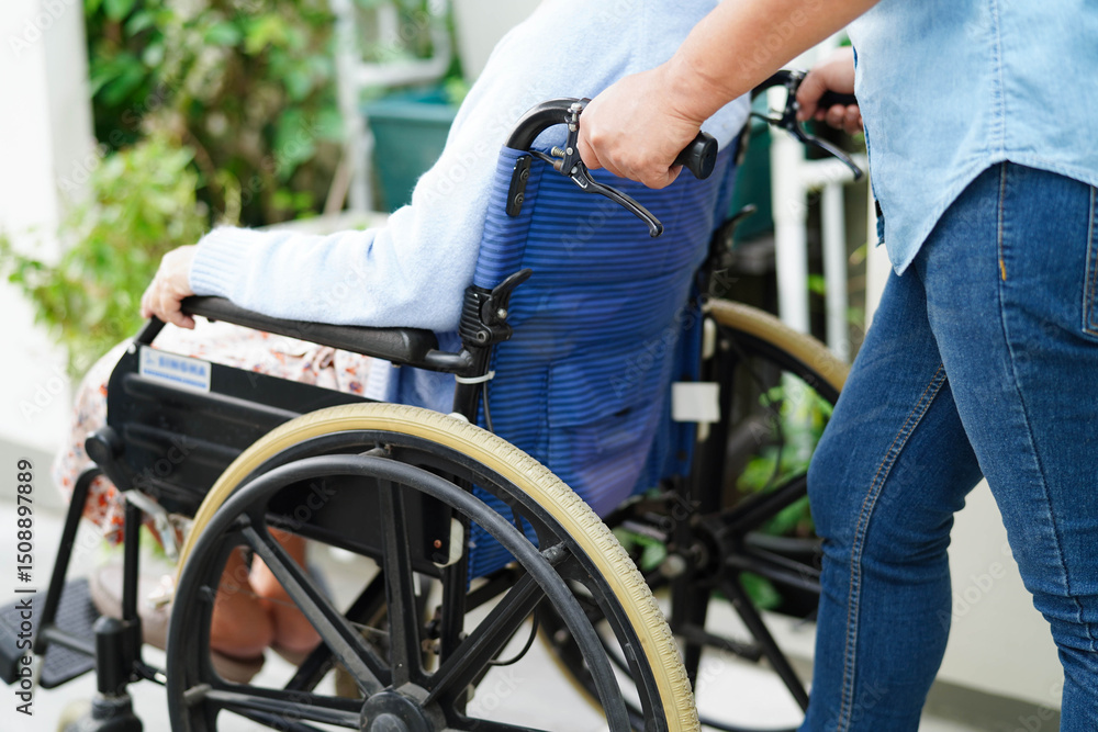 Obraz premium Caregiver help Asian elderly woman disability patient sitting on wheelchair in hospital.