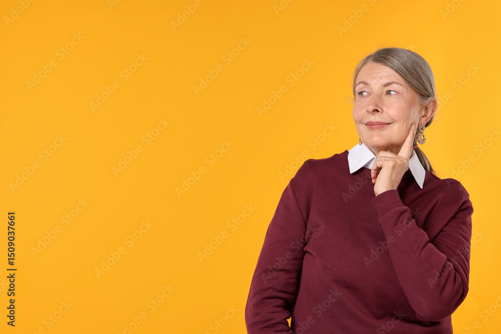 Happy senior woman in stylish outfit on orange background, space for text Happy senior woman in stylish outfit on orange background, space for text