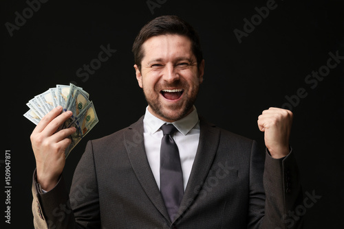 Obraz na plátně Happy greedy banker with dollar banknotes on black background