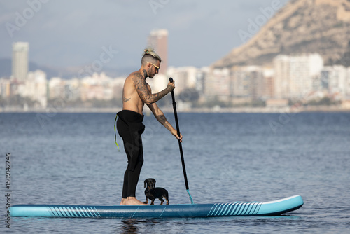 Photography Man paddle surfing with a dog.