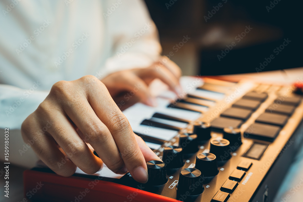 Fototapeta premium Pianist Concept. Close-Up View of a Music Producer Playing MIDI Keyboard with Creative Focus and Artistic Passion in a Studio Environment