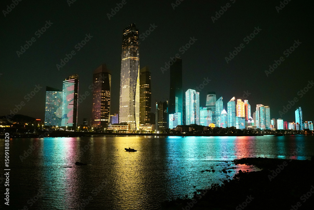Obraz premium City Skyline Illuminated at Night with Reflections