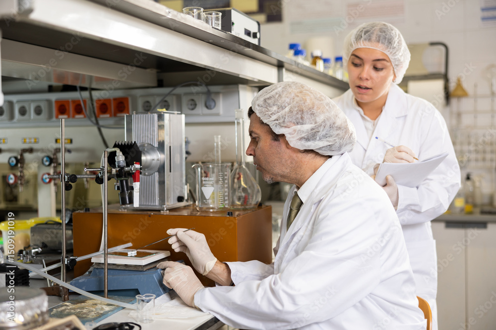 Man and woman scientists chemists conduct various experiments in a research laboratory Man and woman scientists chemists conduct various experiments in a research laboratory