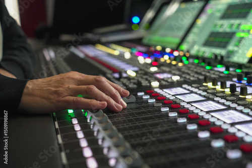 Sound engineer's hand adjusting audio mixer console in Fernsehenstudio