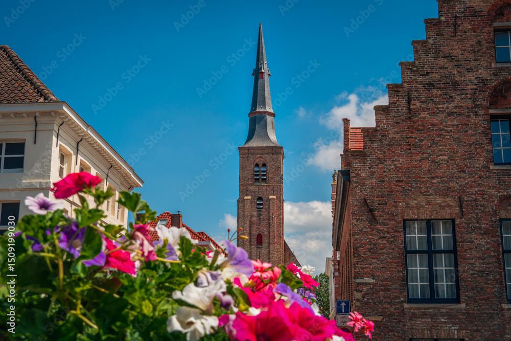 Obraz premium church of our lady of our lady in bruges belgium with flowers in summer