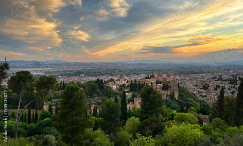 View of the Spanish city of Granada with the Alhambra in the foreground at sunset.