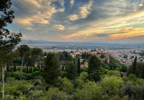 View of the Spanish city of Granada with the Alhambra in the foreground at sunset.