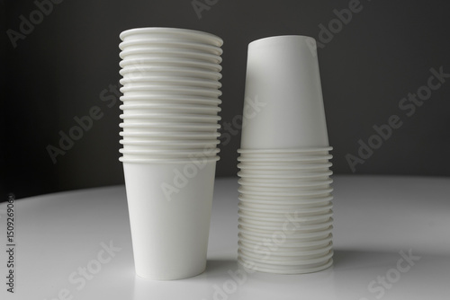 Minimalistic image of white paper cup stacks. Eco-conscious design for sustainable living, coffee shops, events, or branding mockups.