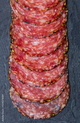 Portion of salami on black stone plate
