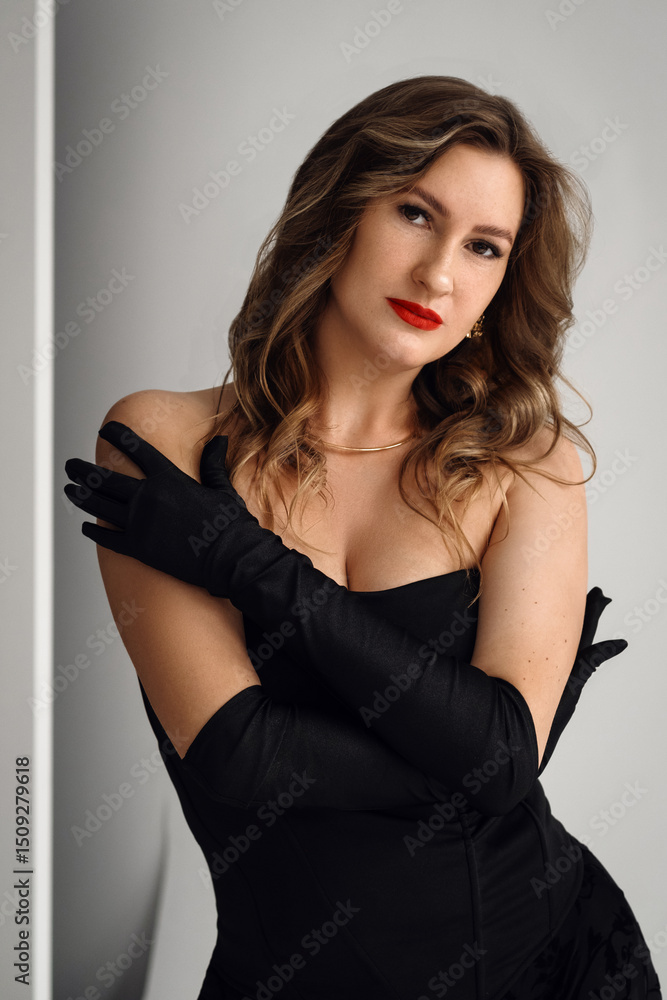 Portrait of beautiful young woman in black dress. long stylish gloves. girl luxury fashion model looks at camera. Pretty face evening makeup sexy eyes, an elegant hairstyle Portrait of beautiful young woman in black dress. long stylish gloves. girl luxury fashion model looks at camera. Pretty face evening makeup sexy eyes, an elegant hairstyle