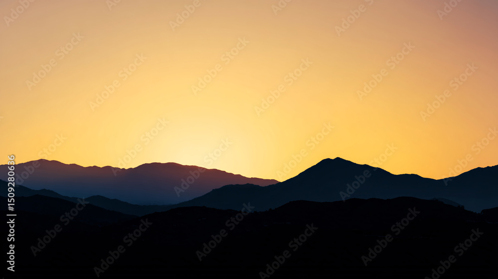 Obraz premium Serene mountain range silhouette at sunset with warm golden sky, creating a peaceful and scenic landscape Concept of nature, travel, and tranquility