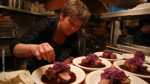 Chef preparing plated dishes of pork tenderloin with a vibrant garnish.