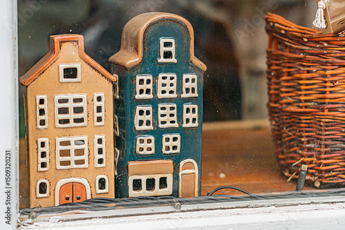Indoor setting with two miniature Dutch houses White, black, red, and brown colored structures with pointed roofs and gabled facades Various window styles, close proximity suggesting community or n