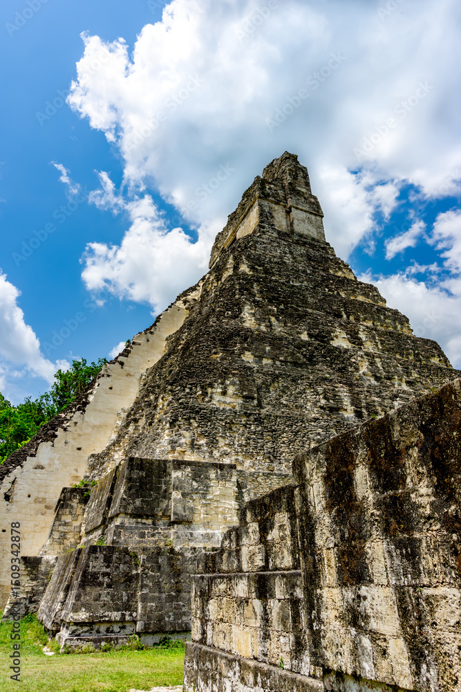 Fototapeta premium The majestic Pyramid of Tikal rises from the Guatemalan jungle, showcasing ancient Mayan architecture, rich history, and breathtaking views in a UNESCO World Heritage Site.