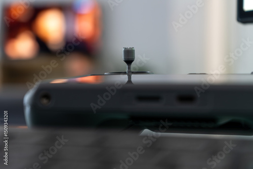 A close up view of the drone's remote control, on the stick, in the evening view