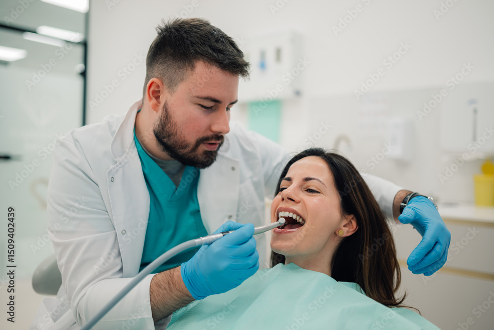 Dentist using dental drill on patient in modern clinic Dentist using dental drill on patient in modern clinic