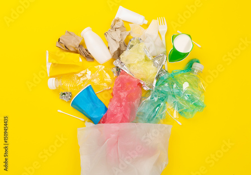 Bag with unsorted waste on color background, top view