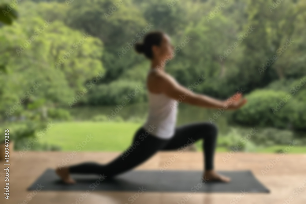Fototapeta premium A blurry image of a woman doing yoga in the open air, showing a fresh and calm natural atmosphere with a blurry outdoor background.