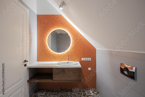 Faucet with sink and round mirror in the bathroom