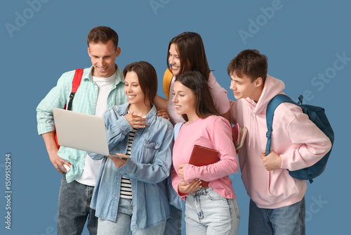 Group of students using laptop on blue background