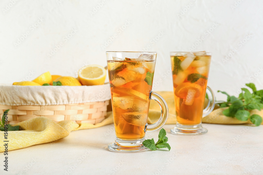Fototapeta premium Glass cups of fresh iced tea on light background