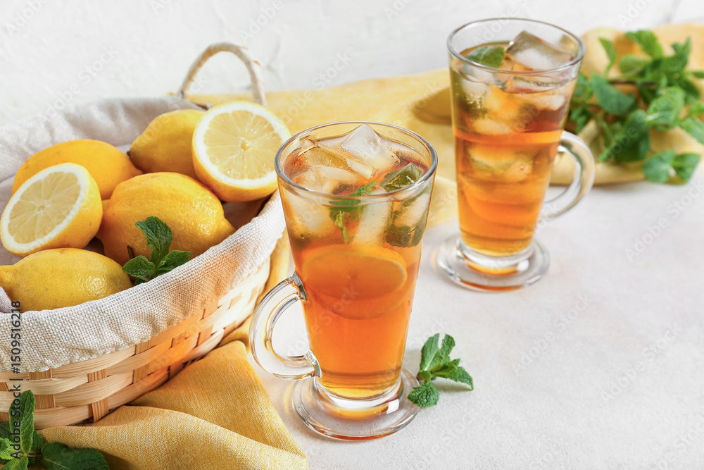 Fototapeta premium Glass cups of fresh iced tea on light background