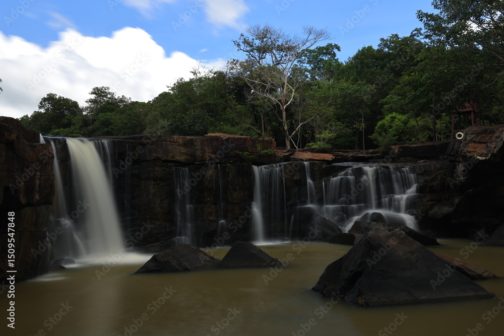 Naklejka premium Tat Ton is a beautiful waterfall with water flowing all year round, On top of it, the water cascades down wide rock plateaus, with big trees lining up on both side of the stream Chaiyaphum ,THAILAND
