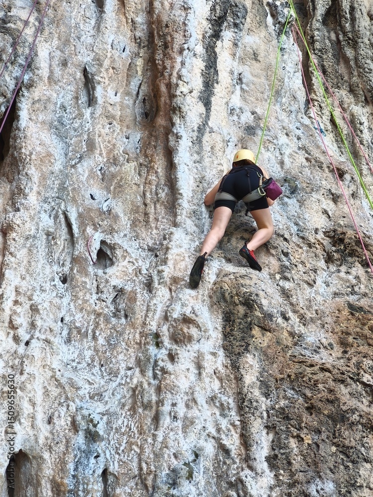 climber on a rock Female athlete top rope rock climbing at Railay Beach, Ao Nang, Krabi Province, Thailand. climber on a rock Female athlete top rope rock climbing at Railay Beach, Ao Nang, Krabi Province, Thailand.