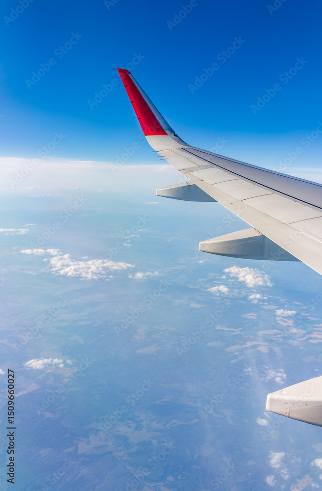 Obraz premium View from the airplane window at a beautiful cloudy sky and the airplane wing