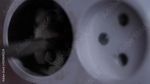 Close-up burnt electrical outlet after short circuit in house, electrician dismantling damaged socket