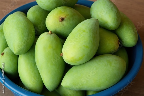 Wallpaper Mural Fresh and Ripe Green Mangoes in a Blue Bowl Displayed on a Wooden Table Surface Perfect for Healthy Eating Concepts and Tropical Fruit Agriculture Torontodigital.ca