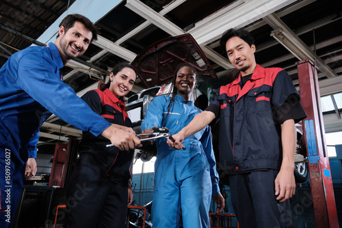 Harmonious professional mechanic teamwork, multiracial engineers with wrenches united, cheerful, and happy smile in fix car garage, maintenance service jobs in automotive transport industry station.