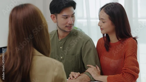 asian financial advisor presenting charts and data on a tablet during couple client meeting.financial planning and decision-making
