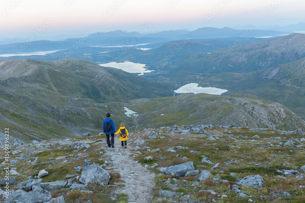 Fototapeta premium Children and adults, family with dog, hiking Grytetippen trail in Senja, Lofoten on a sunny hot summer day